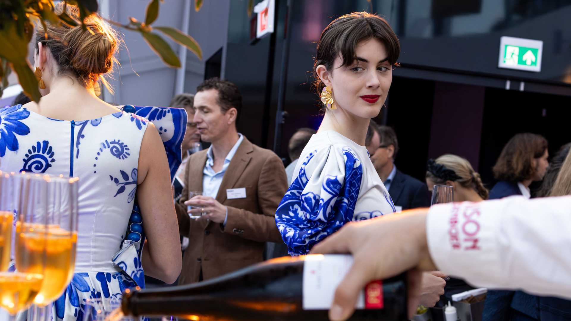 Luxury corporate event welcome experience with themed hostesses and champagne tower display