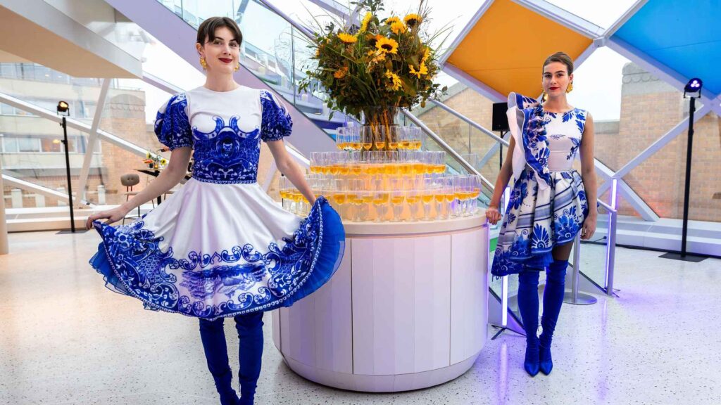 Luxury corporate event welcome experience with themed hostesses and champagne tower display