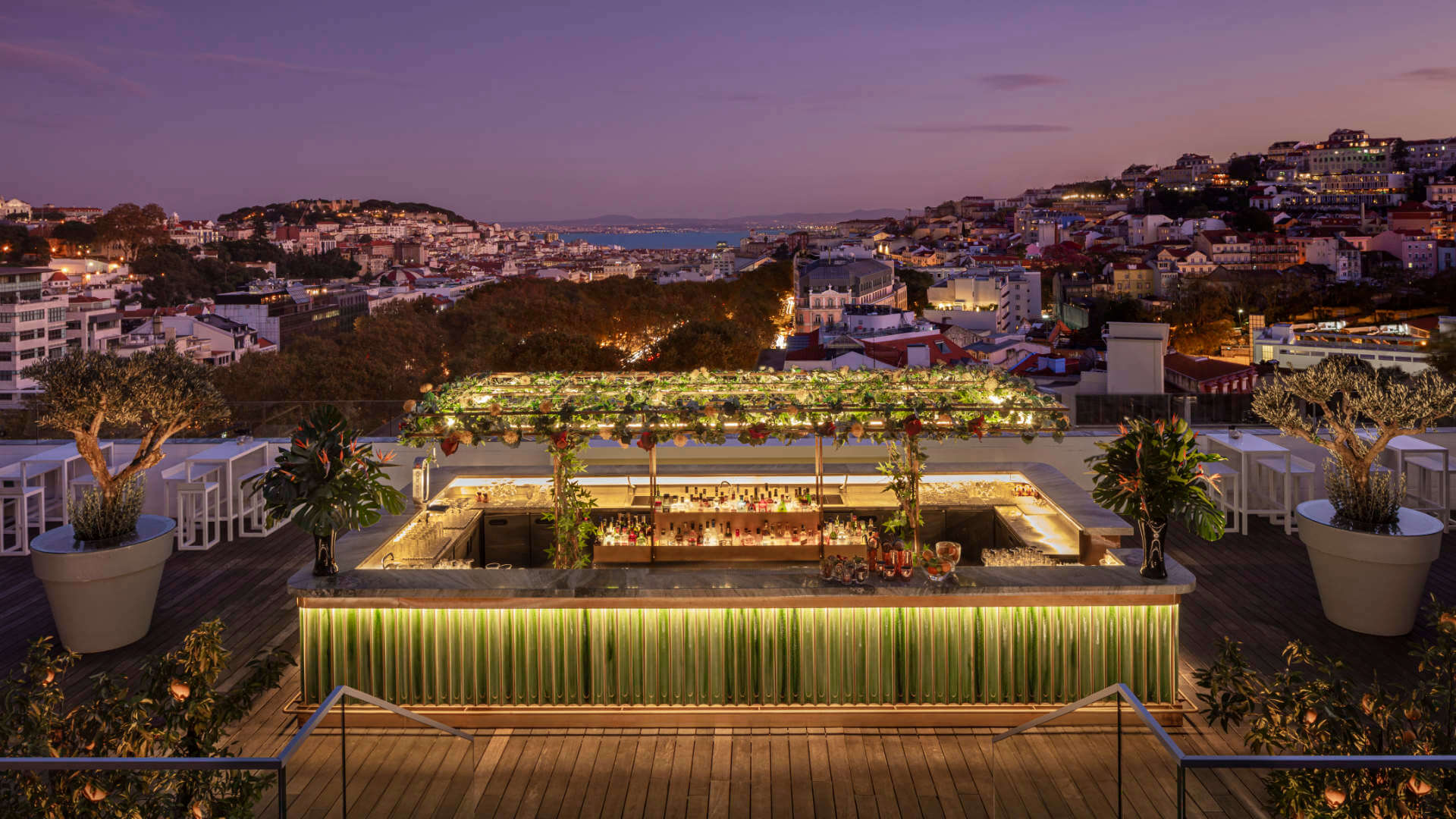 Luxury rooftop event venue in Lisbon featuring panoramic city views, stylish bar setup, and sunset ambiance