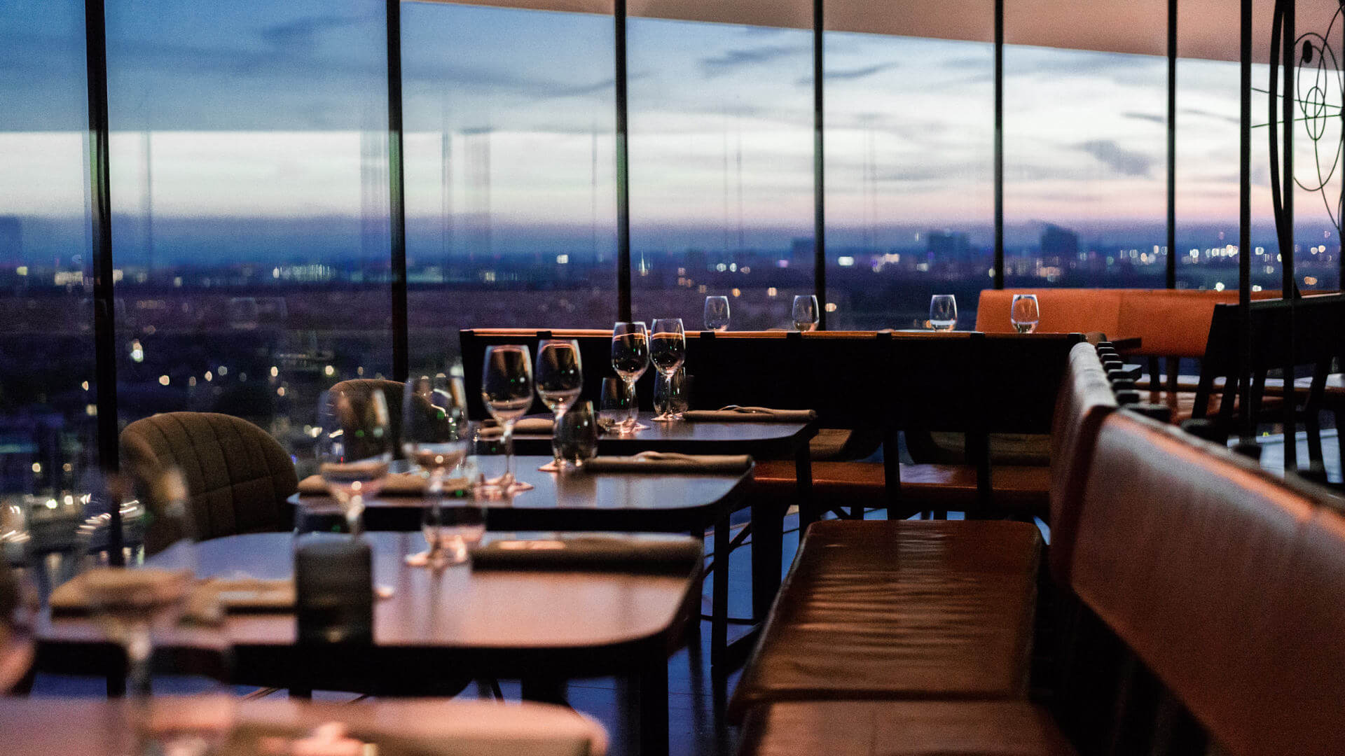 Elegant evening dining experience with city lights and window-side seating in a high-rise venue