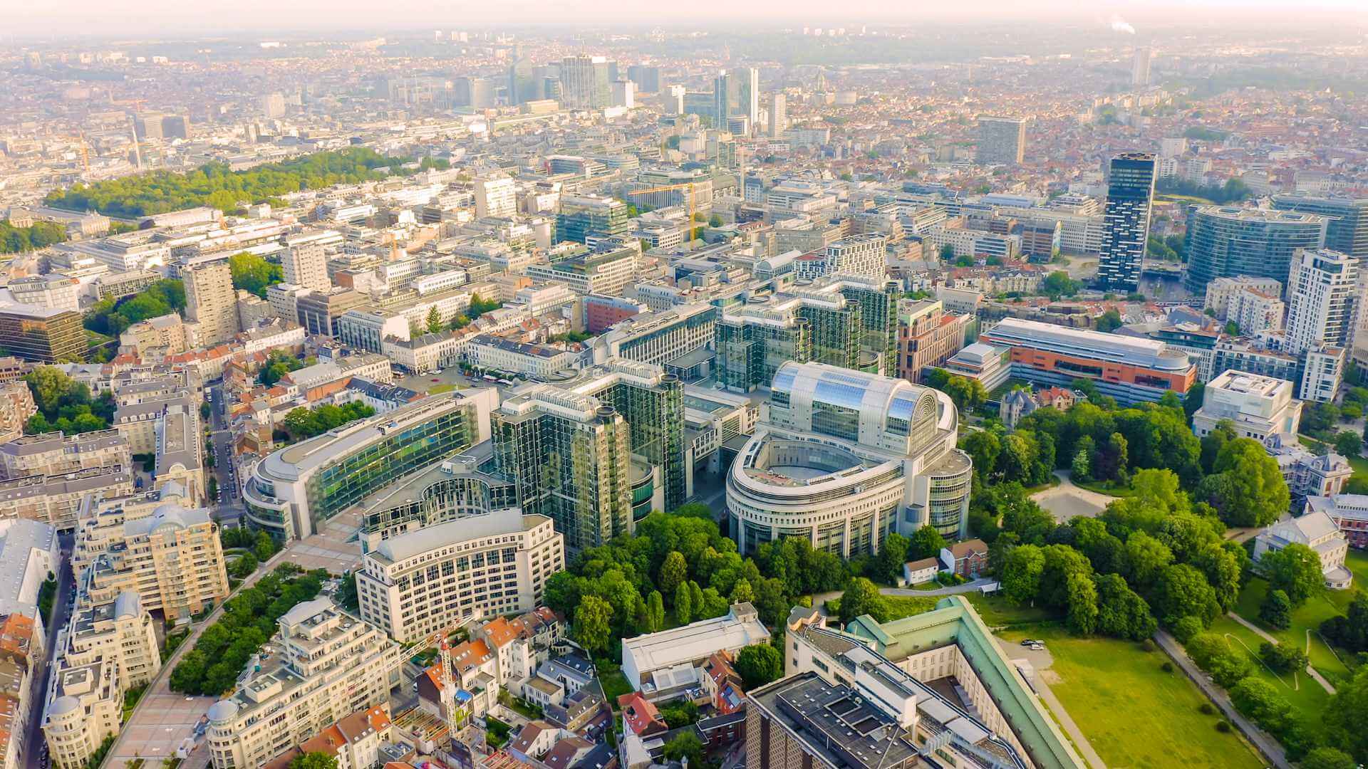 Aerial view of Brussels showing the European Parliament building and the city's modern business quarter surrounded by green parkland, establishing the Belgian capital as a key European corporate event destination.