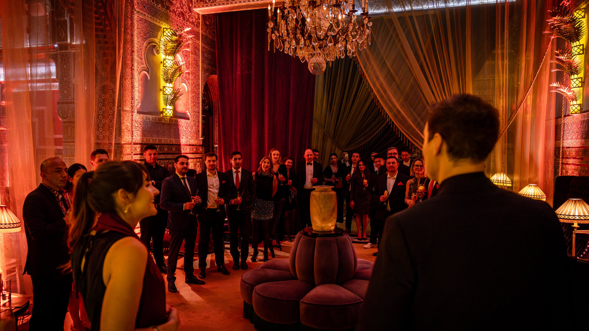 Corporate incentive group gathered in an ornately decorated Moroccan ballroom at a welcome reception — the moment when a well-designed programme rotation should be invisible to guests and felt only as a smooth, unhurried arrival