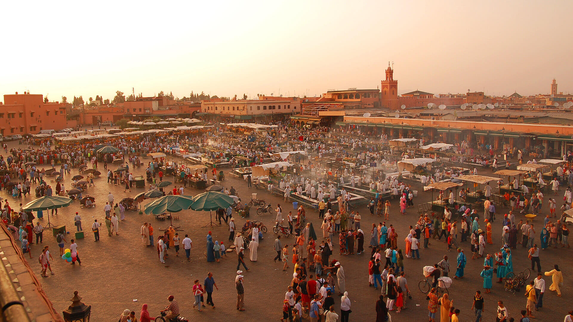 Jemaa el-Fna square seen from above at sunset, filled with food stalls, crowds and smoke — the beating heart of the Medina whose access patterns a Marrakech incentive hotel must be positioned to support
